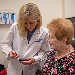 Doctor showing patient a surgical implant.